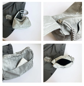 Detail view of silver textured tote bag showing zipper, back pocket and spacious interior