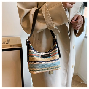 Detail of colorful woven shoulder bag with bohemian stripes and leather strap on model