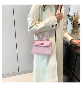 Dettaglio mini borsa a tracolla rosa con paillettes, chiusura a scatto e manico corto