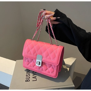 Macro shot of pink quilted pattern with silver chain strap and twist-lock on shoulder bag