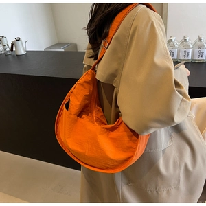 Vue de dos d'un mannequin portant un grand sac bandoulière croissant en nylon orange