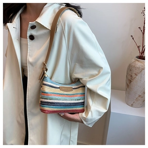 Detail of colorful striped woven tote bag with brown leather strap worn by a model