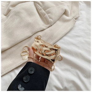 Macro shot of mini gold metallic shell bag with textured finish and fine chain strap