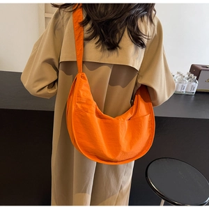 Sac à bandoulière croissant orange vif sur modèle pour un style quotidien et une grande capacité