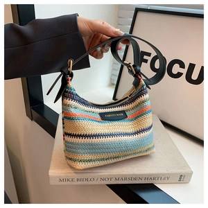 Detail view of colorful striped woven crossbody bag with adjustable black leather strap