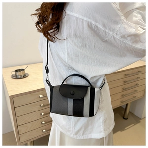 Vue latérale d'un mini sac à bandoulière rayé avec rabat en cuir noir porté par un mannequin