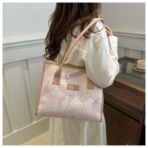 Detail of pink tote bag featuring zigzag colorful embroidery and diamond quilted pattern