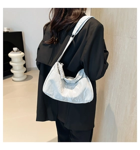 Detailed back view of a white ruched tote bag with textured cloud pleats on female model