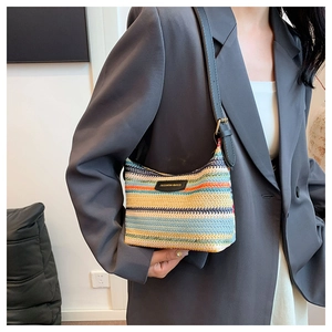 Detail of colorful striped woven pillow bag with fashion leather tag and strap