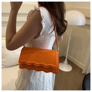 Leuchtend orangefarbene Schultertasche mit Wellenkante und eleganten goldenen Schnallen