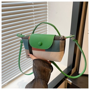 Détail du sac à main en toile bicolore avec rabat vert et bandoulière réglable