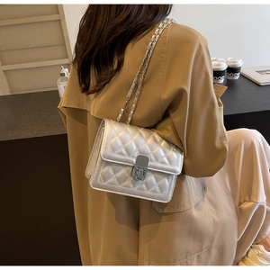 Detail of silver quilted leather bag showing metal chain strap and twist-lock clasp