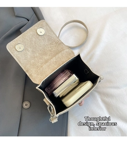 Detail view of the champagne crossbody bag showing spacious interior with magnetic buckles