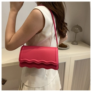 Detail of hot pink shoulder bag featuring unique triple-layered wavy scallop edge design