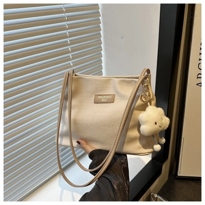 Détail du sac bandoulière texturé gaufré crème avec écusson en cuir Tidal Dryness