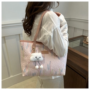 Dettaglio della borsa tote in jacquard rosa con ciondolo a nuvola e manici in pelle