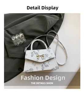 Close-up of cream tote bag featuring purple butterfly patterns and a gold bow clasp
