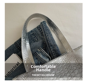 Close-up of silver crocodile embossed leather tote bag with metallic glossy finish