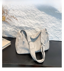 Detail of silver tote bag showing unique crinkled texture and sleek zipper closure