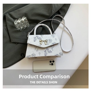 Detail of white leather trapezoid bag with purple butterfly prints and golden bow clasp