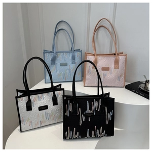 Close-up of textured tote bags in blue, pink, and white with wave patterns