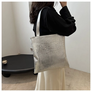 Detail of silver crocodile pattern tote bag shown in a minimalist interior setting