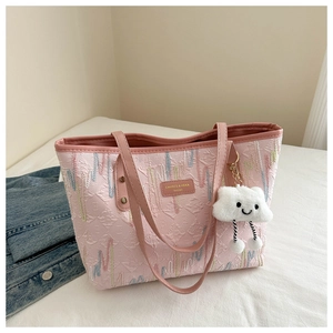 Detail of pink textured tote bag with wave embroidery and cloud plush charm