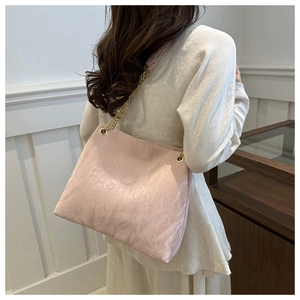Macro detail of pink tote bag with fashion embossing and golden chain strap