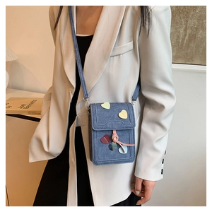 Blue denim crossbody phone bag with colorful heart patches and pink drawstring details