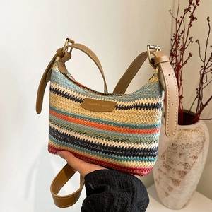 Colorful striped woven crossbody bag with brown leather strap and decorative logo patch