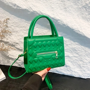Vibrant green quilted crossbody bag with top handles and silver zipper detailing