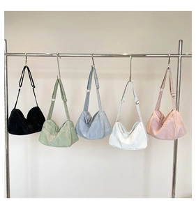 Multiple colors of large capacity nylon crescent tote bags shown on a display rack