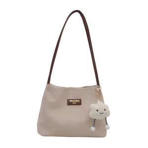 Sac seau minimaliste en tissu gaufré avoine avec bandoulière en cuir marron et breloque