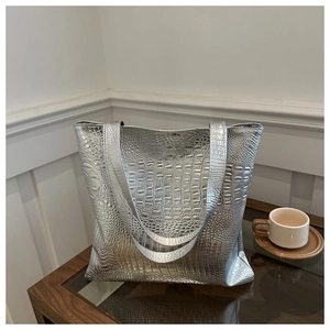 Detailed close-up of glossy silver crocodile embossed texture on a large tote bag