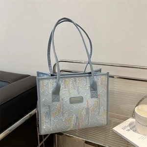 Light blue embroidered tote bag with stylish colorful wave patterns and long shoulder straps
