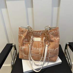 Minimalist large tote bag with orange striped texture and golden chain shoulder strap