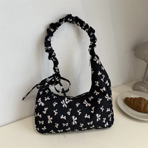 Black canvas shoulder bag with white bow prints and ruched cloud handle for summer