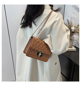 Vue latérale d'un sac à bandoulière matelassé marron avec chaîne sur un modèle