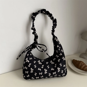 Chic black fabric shoulder bag with cream bow prints and ruched elastic handle design