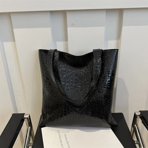 Large black tote bag with glossy crocodile pattern and twin shoulder straps for daily use