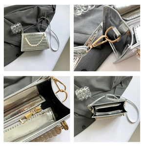 Detail of silver crocodile pattern evening bag with pearl handle and metal hardware
