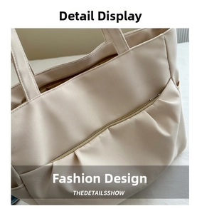 Détail du sac cabas beige montrant la texture du tissu et la poche plissée devant