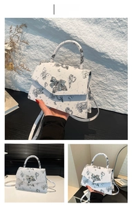 Detailed view of white tote bag with black butterfly prints and silver bow metal buckle