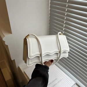 Minimalist ivory white shoulder bag with wave-edge flap and golden metal hardware