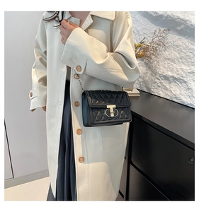 Détail d'un sac à bandoulière en cuir matelassé noir avec fermoir doré et bandoulière chaîne