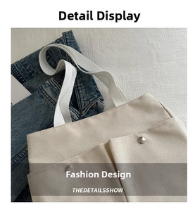 Close-up of beige canvas tote bag showing weave texture and silver buckle detail