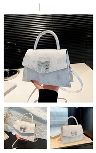 Detail of pink butterfly print handbag with silver bow clasp and trapezoid leather structure