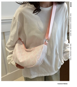 Detail of pink and white woven nylon dumpling bag with adjustable shoulder strap