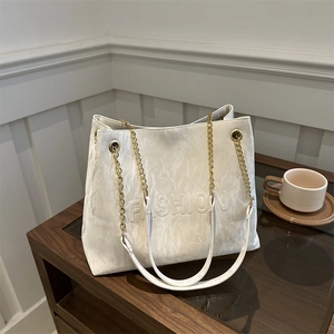 White textured leather tote bag with FASHION embossment and golden chain strap