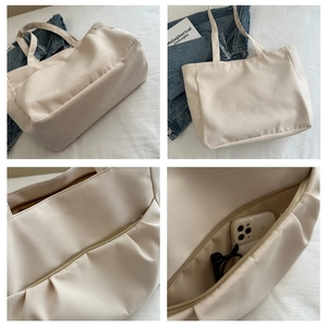 Détail de la poche zippée du sac fourre-tout avec smartphone et lunettes de soleil
